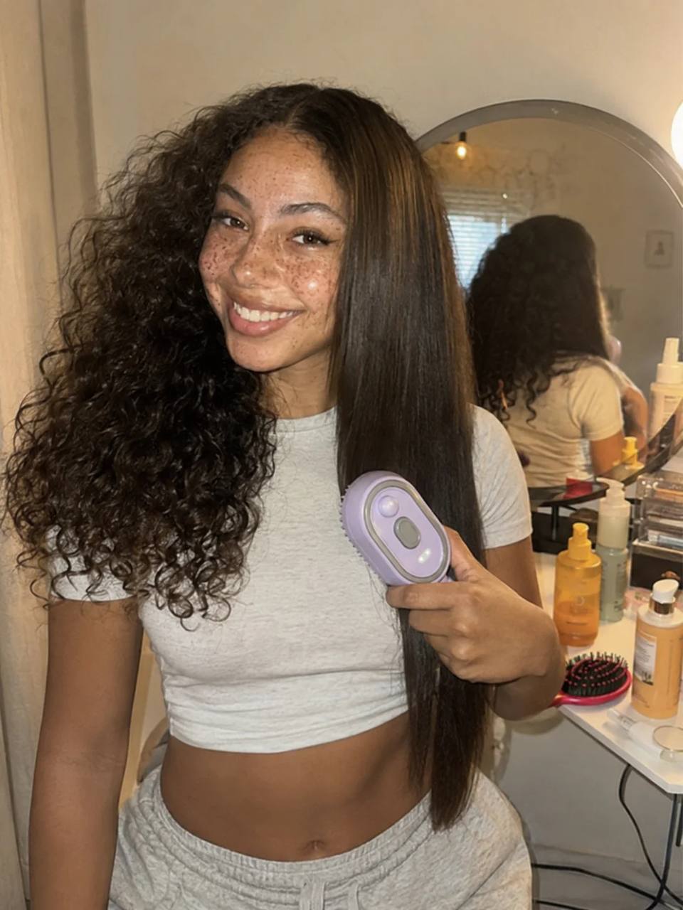 Cliente com cabelo cacheado e liso após uso